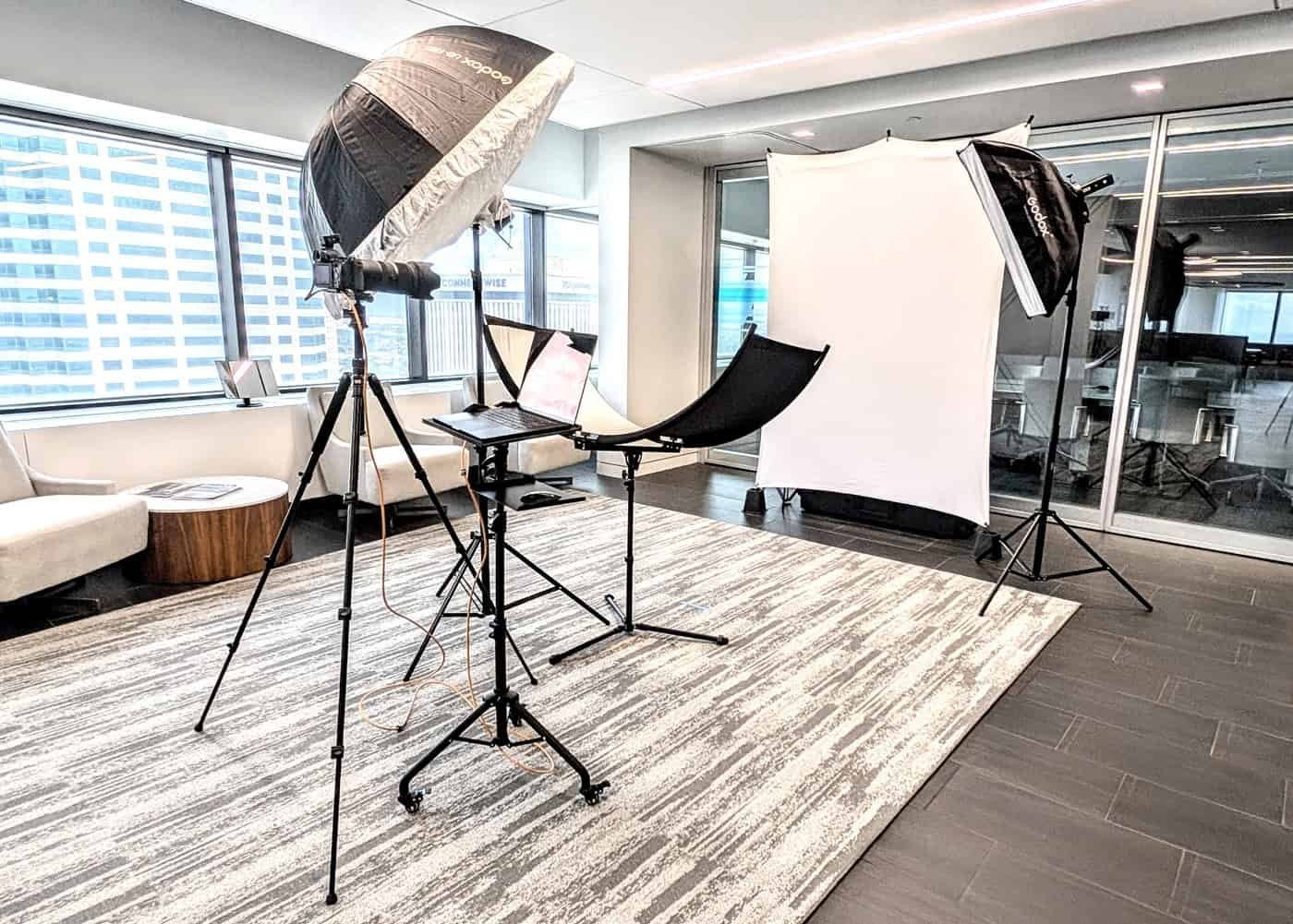 On-site corporate headshot studio setup with softbox lighting, a camera and a white backdrop in an office